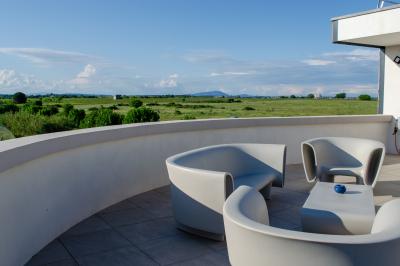 Salle spacieuse avec sol carrelé, éclairage moderne, grandes fenêtres et quelques tables hautes dispersées.