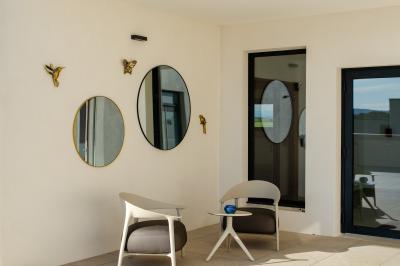 Salle spacieuse avec sol carrelé, éclairage moderne, grandes fenêtres et quelques tables hautes dispersées.