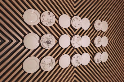 Bâtiment moderne avec façades vitrées et terrasses en bois, entouré de végétation au crépuscule.