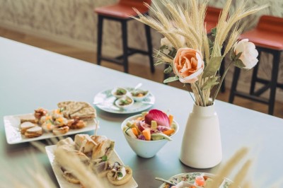 Bâtiment moderne avec façades vitrées et terrasses en bois, entouré de végétation au crépuscule.