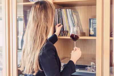 Bâtiment moderne avec façades vitrées et terrasses en bois, entouré de végétation au crépuscule.