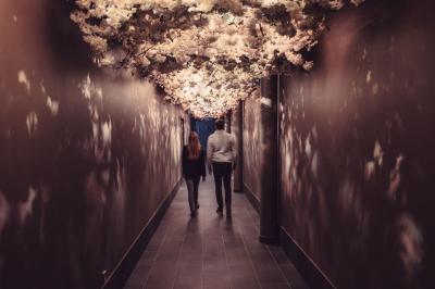 Vue aérienne d'une terrasse animée entourée de vignes au coucher du soleil, avec des invités profitant du cadre.