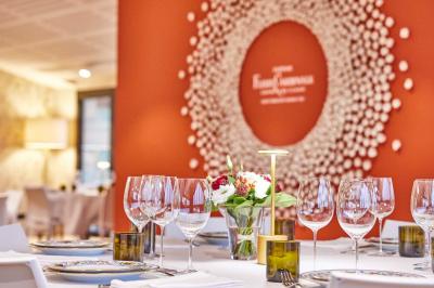 Vue aérienne d'une terrasse animée entourée de vignes au coucher du soleil, avec des invités profitant du cadre.