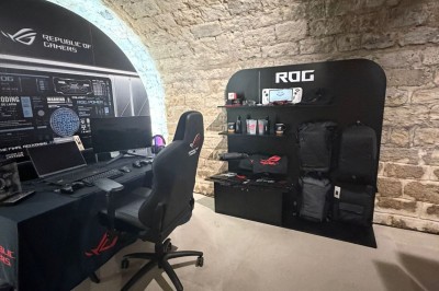 Façade d'une boutique avec vitrines éclairées, affichant des produits ASUS et une pancarte d'accueil pour un événement.