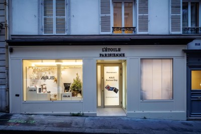 Façade d'une boutique avec vitrines éclairées, affichant des produits ASUS et une pancarte d'accueil pour un événement.