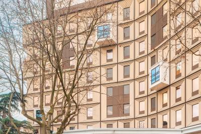 Façade d'un bâtiment moderne avec de grandes fenêtres, des arbres devant et une entrée vitrée portant le nom ’Eklo’.