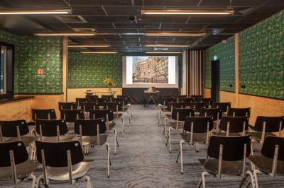 Façade d'un bâtiment moderne avec de grandes fenêtres, des arbres devant et une entrée vitrée portant le nom ’Eklo’.