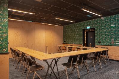 Façade d'un bâtiment moderne avec de grandes fenêtres, des arbres devant et une entrée vitrée portant le nom ’Eklo’.