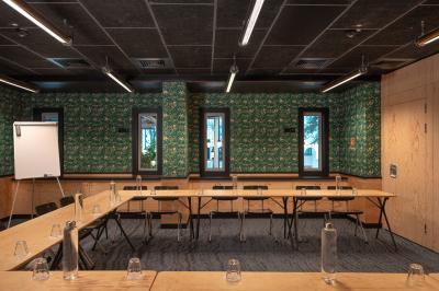 Façade d'un bâtiment moderne avec de grandes fenêtres, des arbres devant et une entrée vitrée portant le nom ’Eklo’.