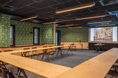 Façade d'un bâtiment moderne avec de grandes fenêtres, des arbres devant et une entrée vitrée portant le nom ’Eklo’.