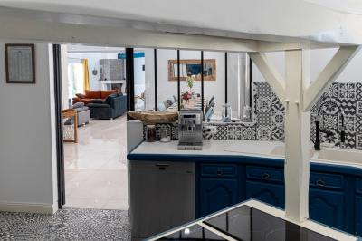 Chambre lumineuse avec lit double, étagère, fenêtre donnant sur l'extérieur et salle de bain attenante avec lavabo moderne.