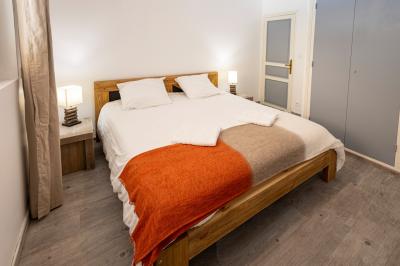 Chambre lumineuse avec lit double, étagère, fenêtre donnant sur l'extérieur et salle de bain attenante avec lavabo moderne.