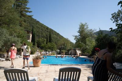 Miniature Location salle Valouse (Drôme) - Hameau de Valouse #10 Salle lumineuse avec tables et chaises en bois, grandes baies vitrées et plafond décoré de motifs végétaux.