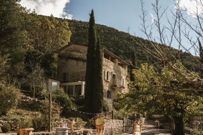 Miniature Location salle Valouse (Drôme) - Hameau de Valouse #2 Salle lumineuse avec tables et chaises en bois, grandes baies vitrées et plafond décoré de motifs végétaux.