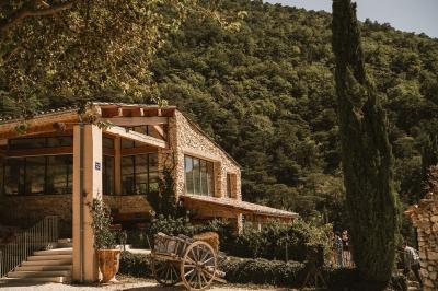 Miniature Location salle Valouse (Drôme) - Hameau de Valouse #20 Salle lumineuse avec tables et chaises en bois, grandes baies vitrées et plafond décoré de motifs végétaux.