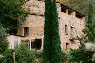 Miniature Location salle Valouse (Drôme) - Hameau de Valouse #29 Salle lumineuse avec tables et chaises en bois, grandes baies vitrées et plafond décoré de motifs végétaux.