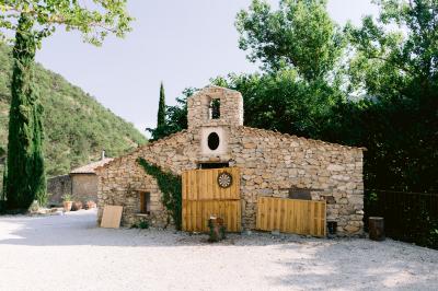 Miniature Location salle Valouse (Drôme) - Hameau de Valouse #35 Salle lumineuse avec tables et chaises en bois, grandes baies vitrées et plafond décoré de motifs végétaux.