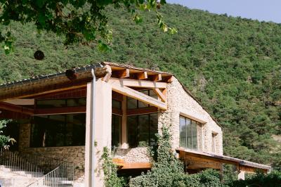 Miniature Location salle Valouse (Drôme) - Hameau de Valouse #36 Salle lumineuse avec tables et chaises en bois, grandes baies vitrées et plafond décoré de motifs végétaux.