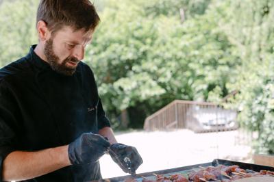Miniature Location salle Valouse (Drôme) - Hameau de Valouse #48 Salle lumineuse avec tables et chaises en bois, grandes baies vitrées et plafond décoré de motifs végétaux.