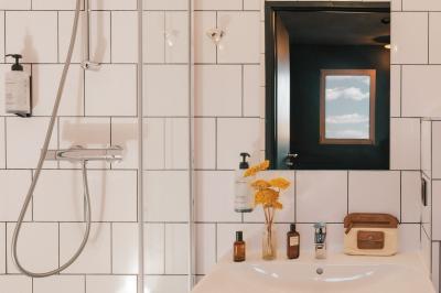 Façade d'un bâtiment moderne avec une enseigne lumineuse ’eklo’, des baies vitrées et des tables en terrasse.