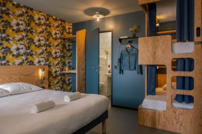 Façade d'un bâtiment moderne avec enseigne lumineuse ’eklo’, terrasse aménagée et intérieur éclairé visible.