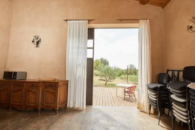 Petite pièce avec plafond en bois, coin cuisine équipé, table en bois et buffet rustique, vue sur une porte ouverte.