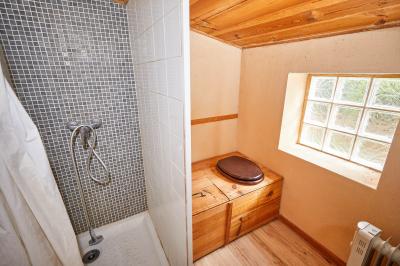 Petite pièce avec plafond en bois, coin cuisine équipé, table en bois et buffet rustique, vue sur une porte ouverte.
