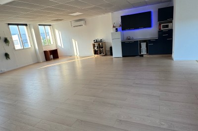 Toilettes modernes avec murs et sol en carrelage effet marbre, lavabo compact et étagères murales minimalistes.