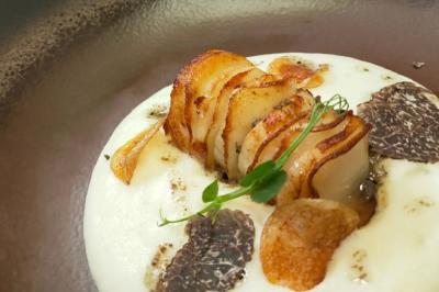 Noix de Saint-Jacques poêlées, purée de légumes, chips croustillantes et décoration de jeunes pousses.