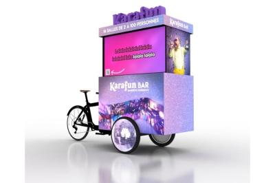 Deux personnes discutent gestuellement lors d'une soirée avec une DJ en arrière-plan et des lumières colorées.