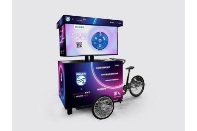 Deux personnes discutent gestuellement lors d'une soirée avec une DJ en arrière-plan et des lumières colorées.