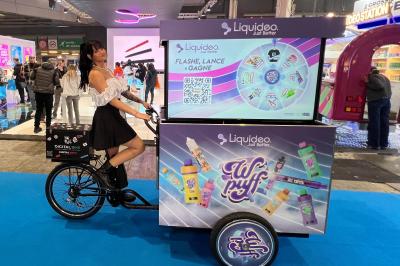 Deux personnes discutent gestuellement lors d'une soirée avec une DJ en arrière-plan et des lumières colorées.