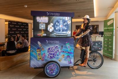 Deux personnes discutent gestuellement lors d'une soirée avec une DJ en arrière-plan et des lumières colorées.