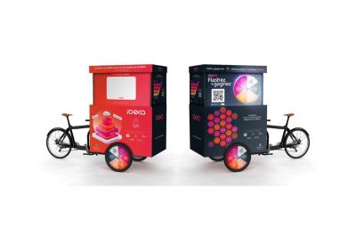 Deux personnes discutent gestuellement lors d'une soirée avec une DJ en arrière-plan et des lumières colorées.