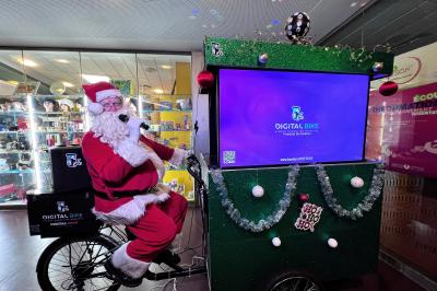 Une DJ joue de la musique sur une scène mobile montée sur un vélo, dans une cour extérieure.