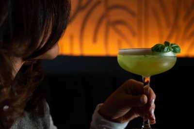 Assortiment de plats variés comprenant légumes, tartines, salade, samoussas et sauce, disposés sur une table sombre.