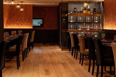 Assortiment de plats variés comprenant légumes, tartines, salade, samoussas et sauce, disposés sur une table sombre.