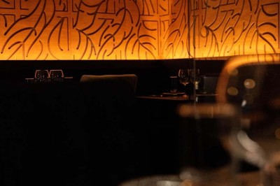 Assortiment de plats variés comprenant légumes, tartines, salade, samoussas et sauce, disposés sur une table sombre.