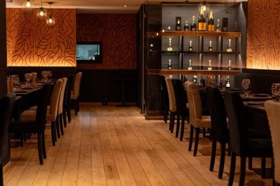 Assortiment de plats variés comprenant légumes, tartines, salade, samoussas et sauce, disposés sur une table sombre.