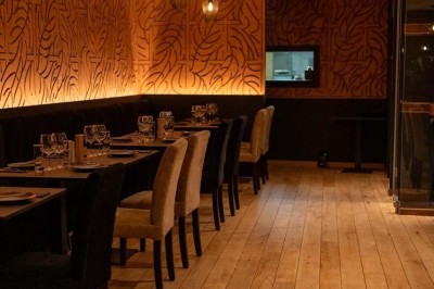 Assortiment de plats variés comprenant légumes, tartines, salade, samoussas et sauce, disposés sur une table sombre.