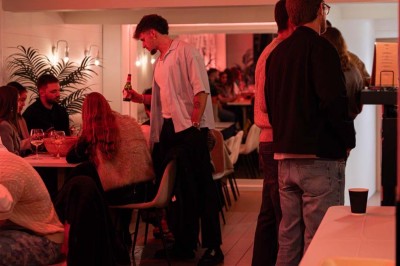 Assortiment de plats variés comprenant légumes, tartines, salade, samoussas et sauce, disposés sur une table sombre.