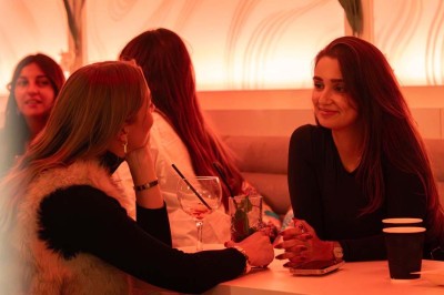 Assortiment de plats variés comprenant légumes, tartines, salade, samoussas et sauce, disposés sur une table sombre.