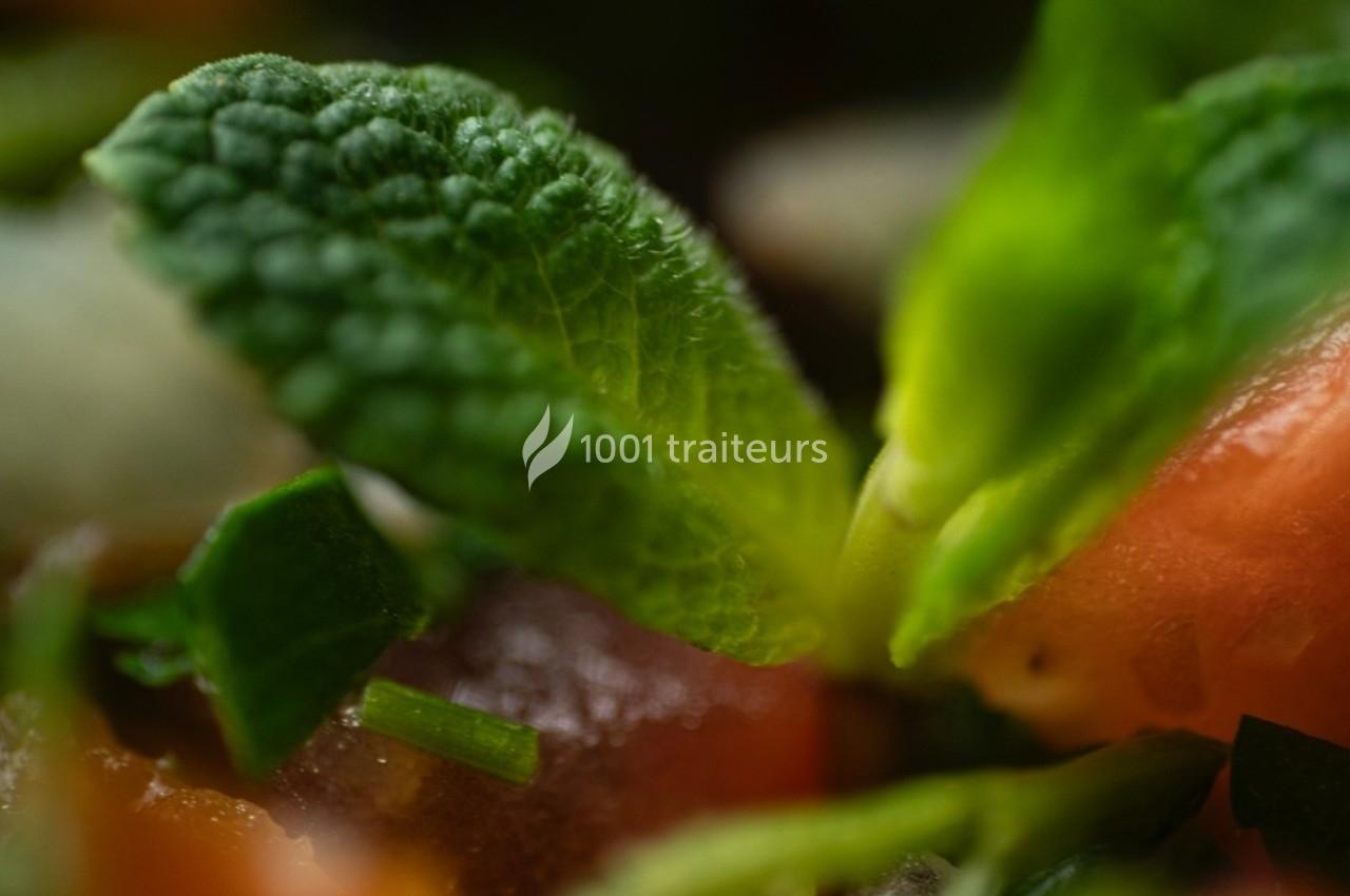 Feuilles de menthe fraîche entourées de morceaux de tomate et d'herbes hachées.