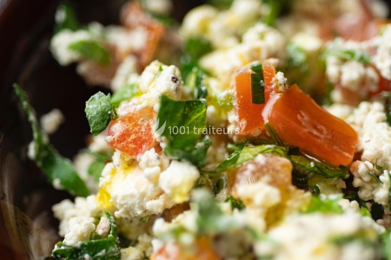 Salade composée de tomates, fromage frais, herbes fraîches et assaisonnement, vue en gros plan.