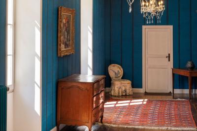 Table dressée pour le petit-déjeuner dans une salle à manger élégante avec chaises en bois et buffet en arrière-plan.