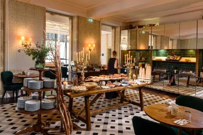 Salle de bain lumineuse avec vasque blanche, serviettes pliées et vue sur un jardin à travers une porte-fenêtre.