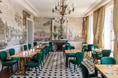 Salle de bain lumineuse avec vasque blanche, serviettes pliées et vue sur un jardin à travers une porte-fenêtre.