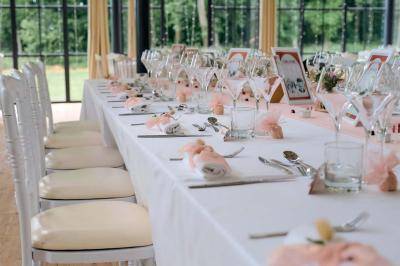 Salle de bain lumineuse avec vasque blanche, serviettes pliées et vue sur un jardin à travers une porte-fenêtre.