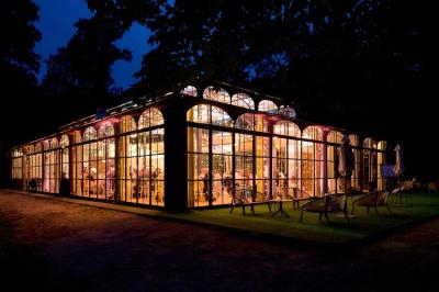 Salle de bain lumineuse avec vasque blanche, serviettes pliées et vue sur un jardin à travers une porte-fenêtre.
