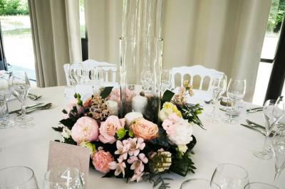 Salle de bain lumineuse avec vasque blanche, serviettes pliées et vue sur un jardin à travers une porte-fenêtre.